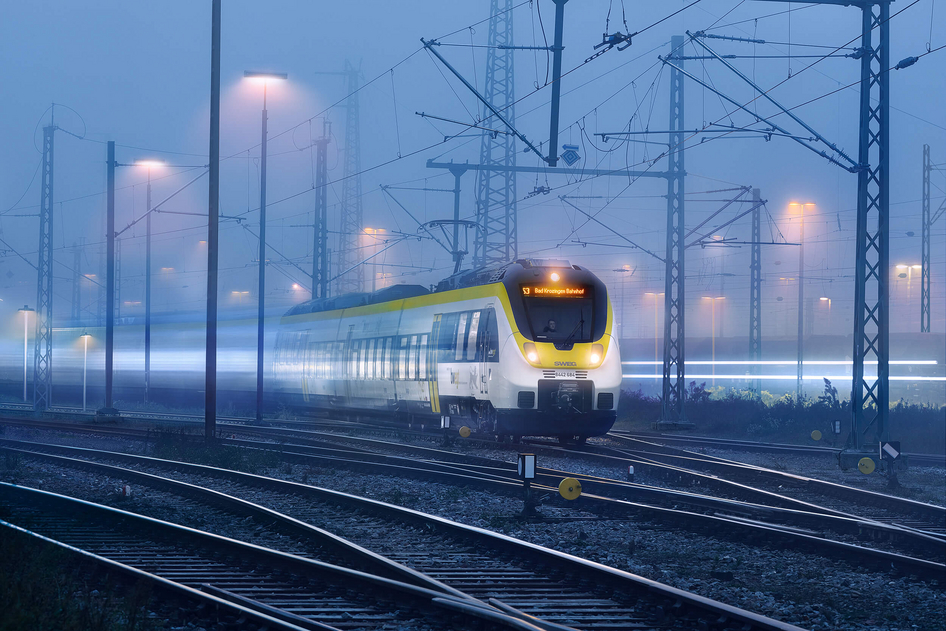 Le train jaune et blanc de la SWEG circule de nuit.