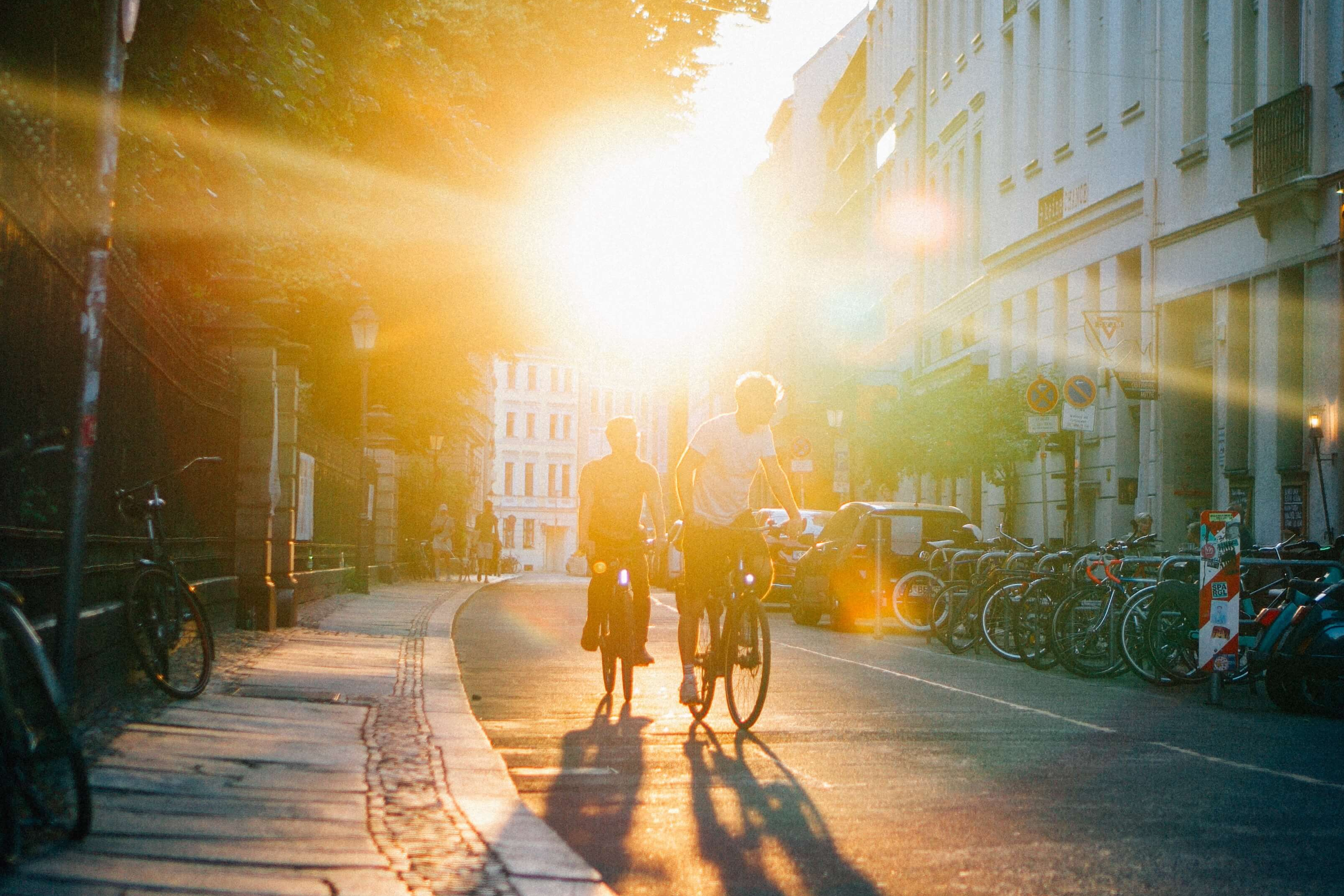 Deux cyclistes roulent sur la route au coucher du soleil